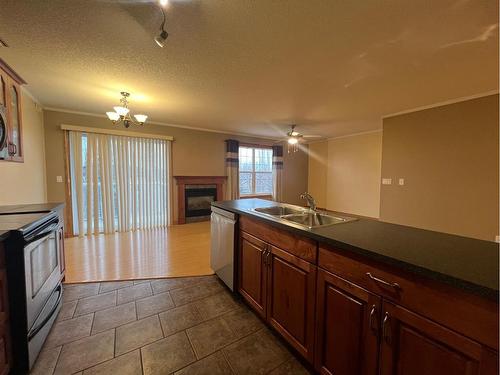 #303-4330A 55 Avenue, Whitecourt, AB - Indoor Photo Showing Kitchen With Fireplace With Double Sink