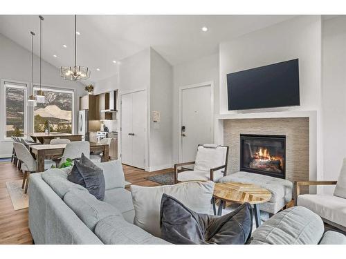 301B-209 Stewart Creek Rise, Canmore, AB - Indoor Photo Showing Living Room With Fireplace