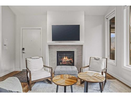 301B-209 Stewart Creek Rise, Canmore, AB - Indoor Photo Showing Living Room With Fireplace