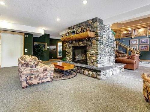 207-155 Crossbow Place, Canmore, AB - Indoor Photo Showing Living Room With Fireplace