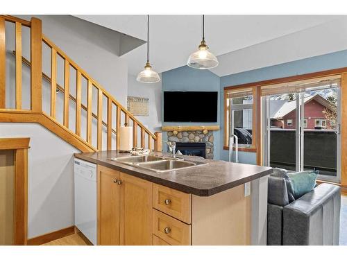 323-107 Montane Road, Canmore, AB - Indoor Photo Showing Kitchen With Fireplace With Double Sink