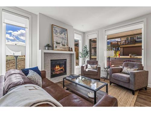 204I-209 Stewart Creek Rise, Canmore, AB - Indoor Photo Showing Living Room With Fireplace