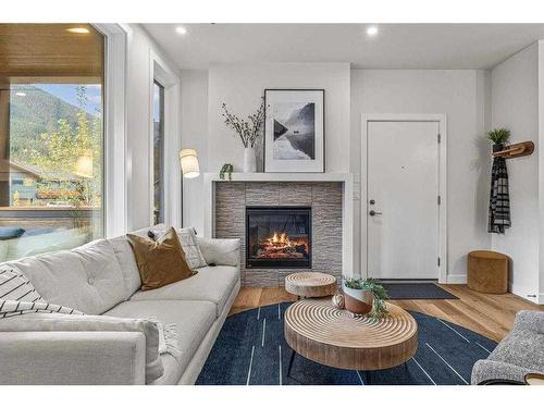 201F-209 Stewart Creek Rise, Canmore, AB - Indoor Photo Showing Living Room With Fireplace