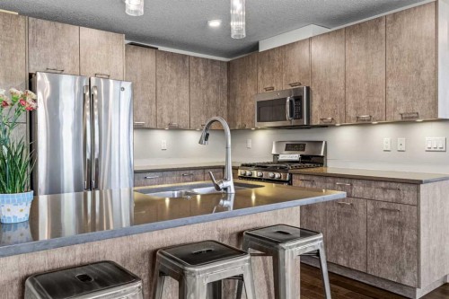 302-102 Stewart Creek Rise, Canmore, AB - Indoor Photo Showing Kitchen With Stainless Steel Kitchen With Double Sink With Upgraded Kitchen