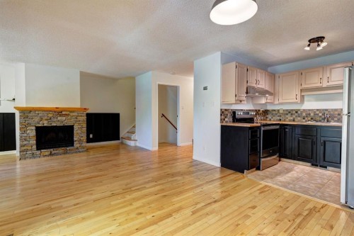 105-200 Three Sisters Drive, Canmore, AB - Indoor Photo Showing Kitchen With Fireplace