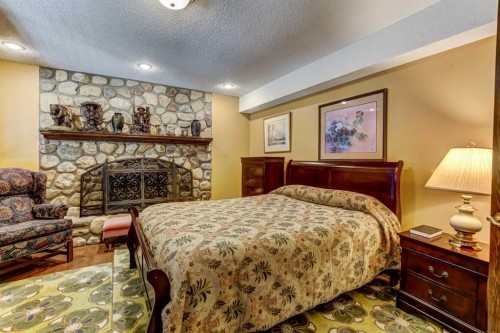5 Cascade Court, Banff, AB - Indoor Photo Showing Bedroom With Fireplace