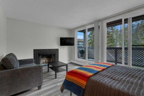 111-414 Squirrel Street, Banff, AB - Indoor Photo Showing Living Room With Fireplace