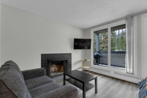 111-414 Squirrel Street, Banff, AB - Indoor Photo Showing Living Room With Fireplace