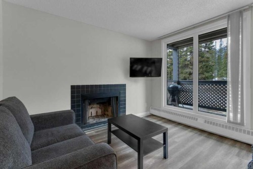 111-414 Squirrel Street, Banff, AB - Indoor Photo Showing Living Room With Fireplace