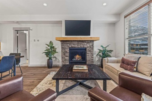 302-1105 Spring Creek Drive, Canmore, AB - Indoor Photo Showing Living Room With Fireplace