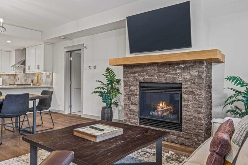 302-1105 Spring Creek Drive, Canmore, AB - Indoor Photo Showing Living Room With Fireplace