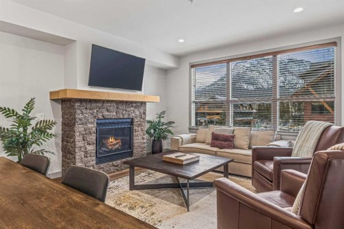 302-1105 Spring Creek Drive, Canmore, AB - Indoor Photo Showing Living Room With Fireplace