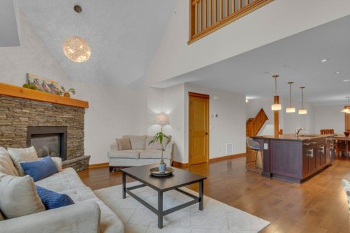 5102-101E Stewart Creek Landing, Canmore, AB - Indoor Photo Showing Living Room With Fireplace