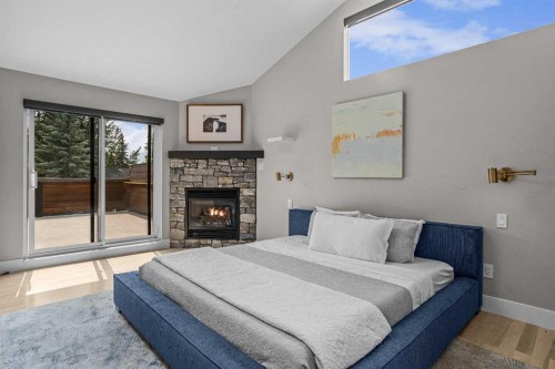 610 Larch Place, Canmore, AB - Indoor Photo Showing Bedroom With Fireplace