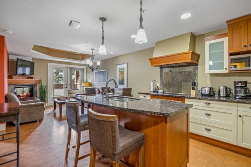 305L-191 Kananaskis, Canmore, AB - Indoor Photo Showing Kitchen With Fireplace With Double Sink