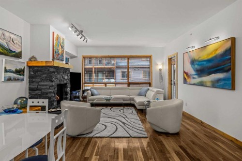 205-600 Spring Creek Drive, Canmore, AB - Indoor Photo Showing Living Room With Fireplace