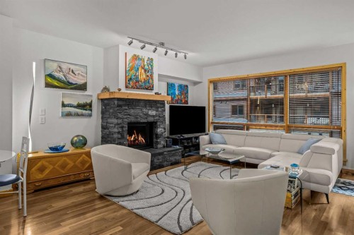 205-600 Spring Creek Drive, Canmore, AB - Indoor Photo Showing Living Room With Fireplace