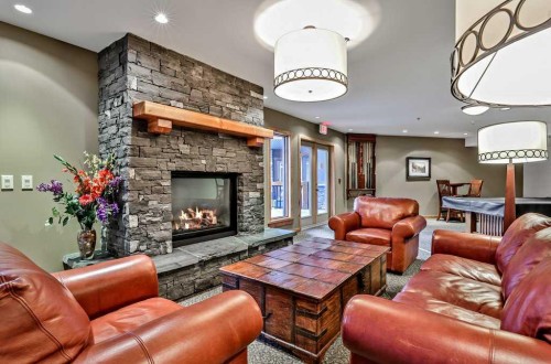 205-600 Spring Creek Drive, Canmore, AB - Indoor Photo Showing Living Room With Fireplace