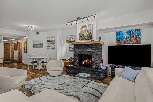 205-600 Spring Creek Drive, Canmore, AB - Indoor Photo Showing Living Room With Fireplace