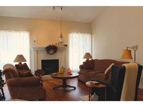 1269 23 Avenue, Didsbury, AB - Indoor Photo Showing Living Room With Fireplace