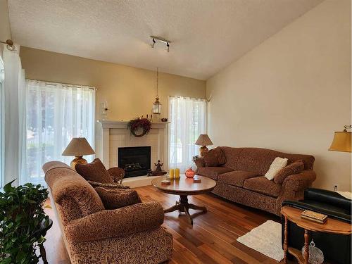 1269 23 Avenue, Didsbury, AB - Indoor Photo Showing Living Room With Fireplace