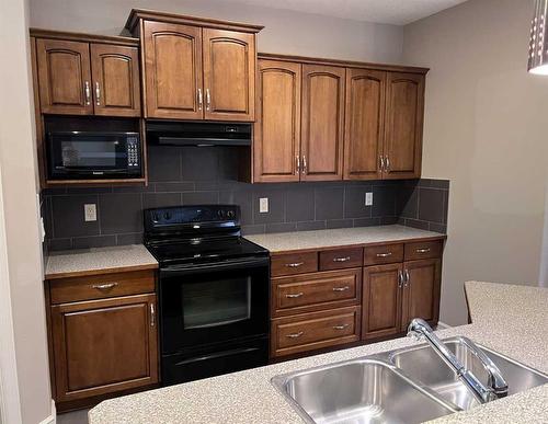 122 Coopers Bay Sw, Airdrie, AB - Indoor Photo Showing Kitchen With Double Sink