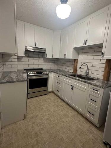 210 4 Avenue East, Hanna, AB - Indoor Photo Showing Kitchen With Double Sink