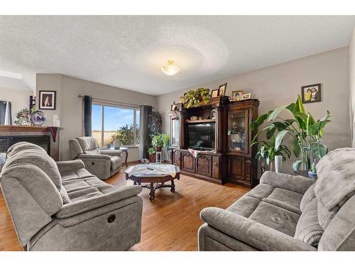 464 Sunset Link, Crossfield, AB - Indoor Photo Showing Living Room With Fireplace