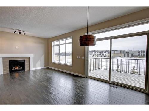 31 Precedence Green, Cochrane, AB - Indoor Photo Showing Living Room With Fireplace