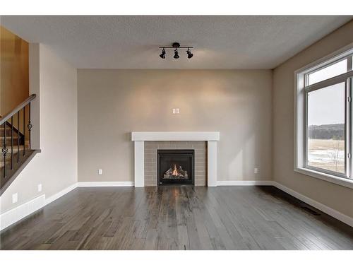 31 Precedence Green, Cochrane, AB - Indoor Photo Showing Living Room With Fireplace