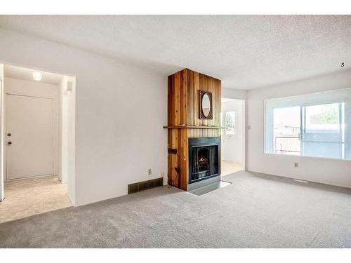 7642 24 Street Se, Calgary, AB - Indoor Photo Showing Living Room With Fireplace