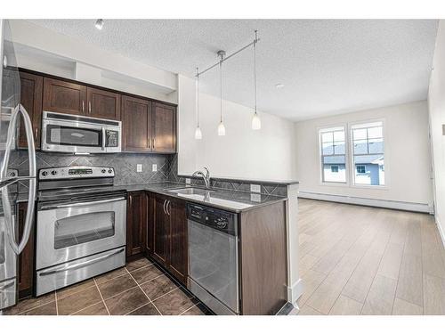 408-201 Sunset Drive, Cochrane, AB - Indoor Photo Showing Kitchen With Stainless Steel Kitchen With Double Sink