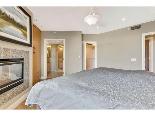 303-837 2 Avenue Sw, Calgary, AB - Indoor Photo Showing Bedroom With Fireplace