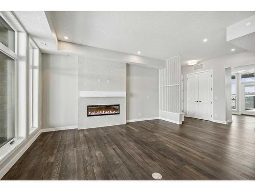 301-110 Marina Cove Se, Calgary, AB - Indoor Photo Showing Living Room With Fireplace