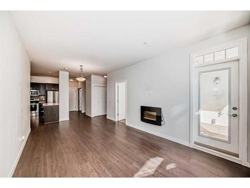 208-22 Auburn Bay Link Se, Calgary, AB - Indoor Photo Showing Living Room With Fireplace