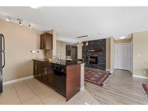 202-195 Kincora Glen Road Nw, Calgary, AB - Indoor Photo Showing Kitchen With Fireplace