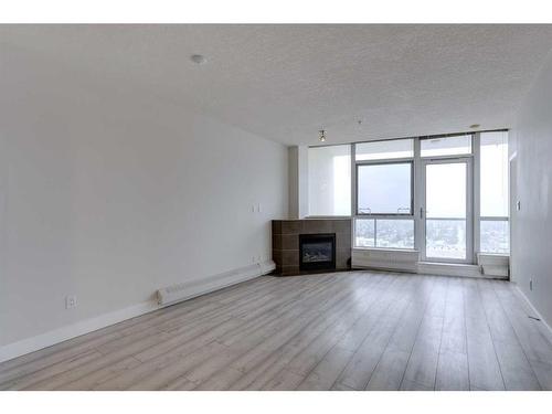 2303-77 Spruce Place Sw, Calgary, AB - Indoor Photo Showing Living Room With Fireplace