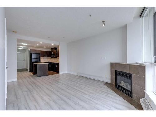 2303-77 Spruce Place Sw, Calgary, AB - Indoor Photo Showing Living Room With Fireplace