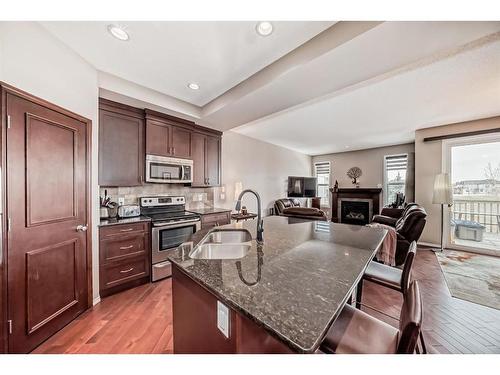 516 Panatella Square Nw, Calgary, AB - Indoor Photo Showing Kitchen With Fireplace With Double Sink