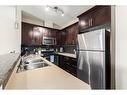 3206-15 Sunset Square, Cochrane, AB  - Indoor Photo Showing Kitchen With Double Sink 