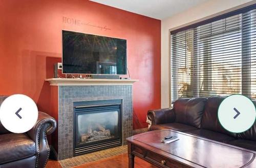 1819 New Brighton Drive Se, Calgary, AB - Indoor Photo Showing Living Room With Fireplace