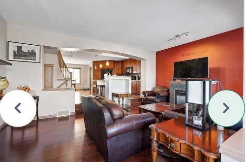 1819 New Brighton Drive Se, Calgary, AB - Indoor Photo Showing Living Room With Fireplace