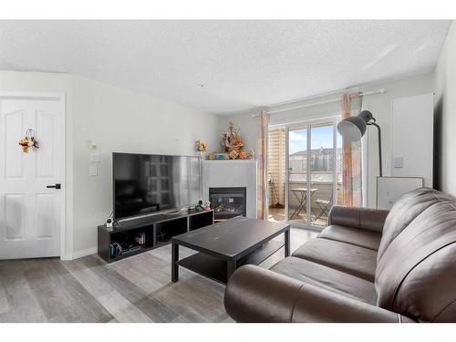 211-6000 Somervale Court Sw, Calgary, AB - Indoor Photo Showing Living Room With Fireplace