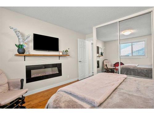 19 Erin Park Bay Se, Calgary, AB - Indoor Photo Showing Bedroom With Fireplace