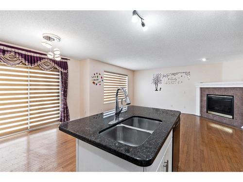 196 Everwillow Green Sw, Calgary, AB - Indoor Photo Showing Kitchen With Fireplace With Double Sink