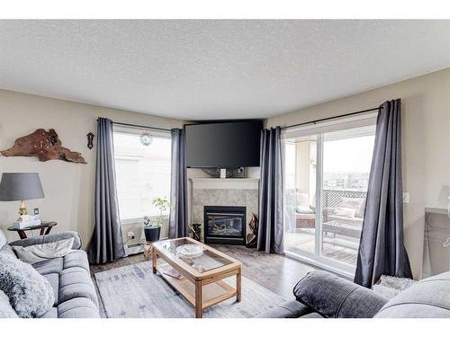 8429-304 Mackenzie Way Sw, Airdrie, AB - Indoor Photo Showing Living Room With Fireplace