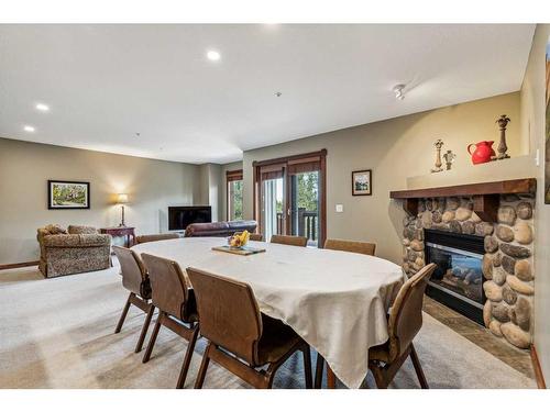 302-170 Crossbow Place, Canmore, AB - Indoor Photo Showing Dining Room With Fireplace