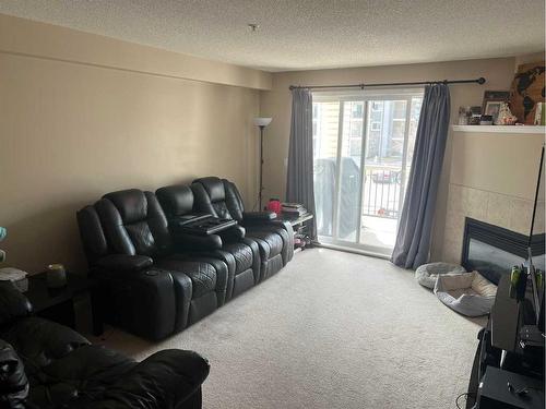 1221-4975 130 Avenue Se, Calgary, AB - Indoor Photo Showing Living Room With Fireplace