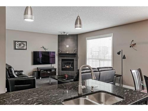 161 Rainbow Falls Heath, Chestermere, AB - Indoor Photo Showing Kitchen With Fireplace With Double Sink