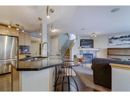 102 Chapalina Rise Se, Calgary, AB - Indoor Photo Showing Kitchen With Fireplace With Double Sink
